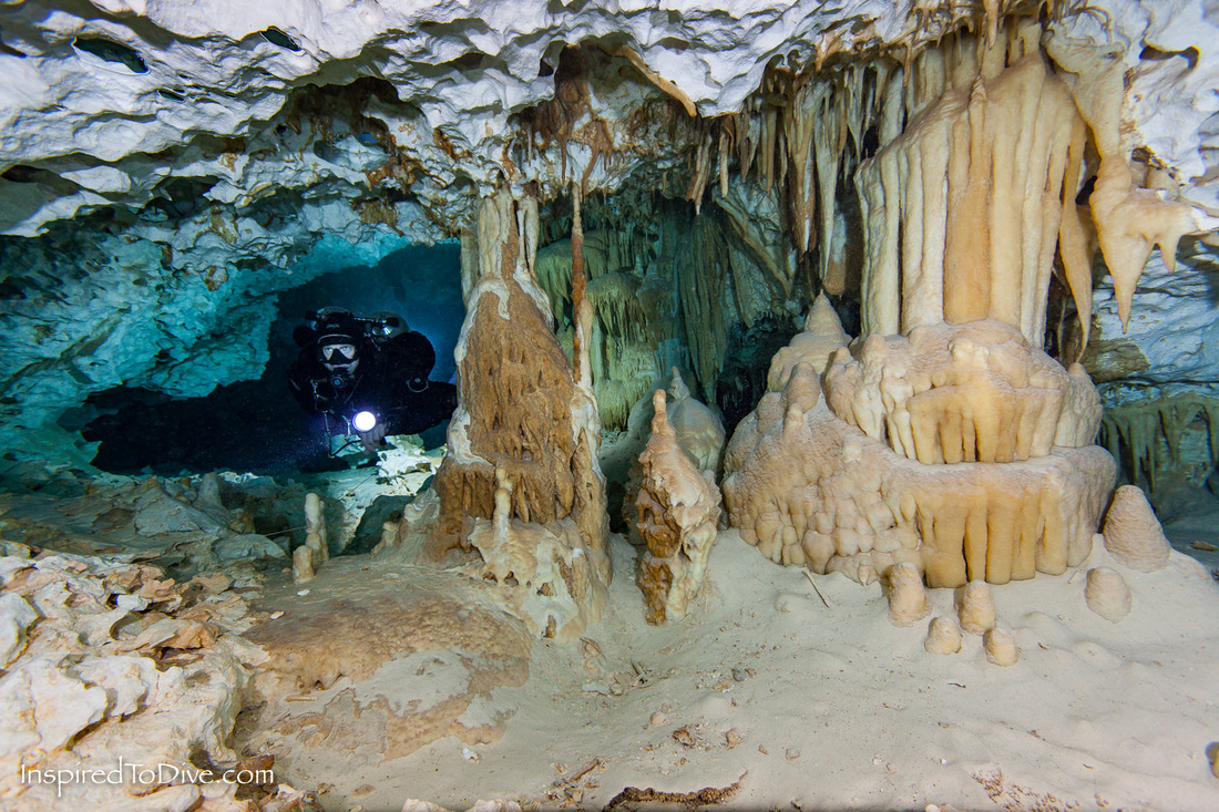 Cave diver Cameron Russo near a wedding cake speleothem rock formation in cave system Dos Ojos in Mexico