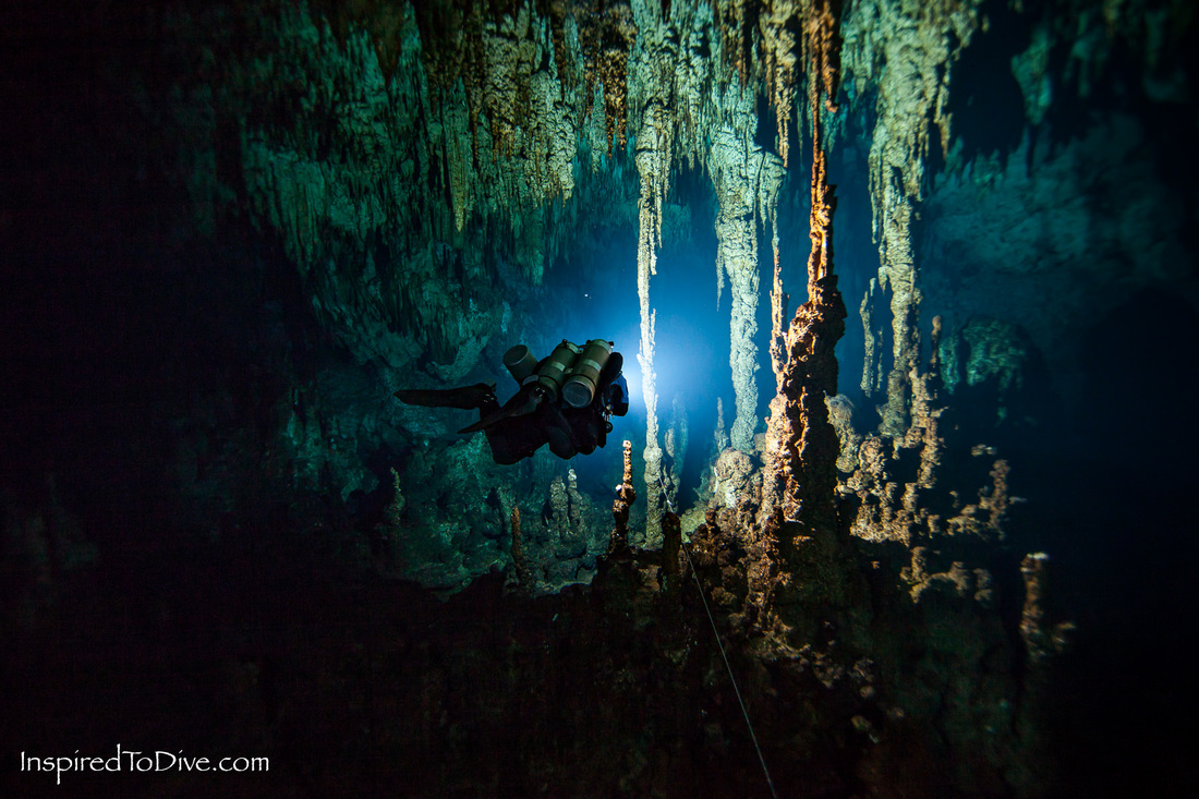 Cave diver passing into formations in a cave in Mexico